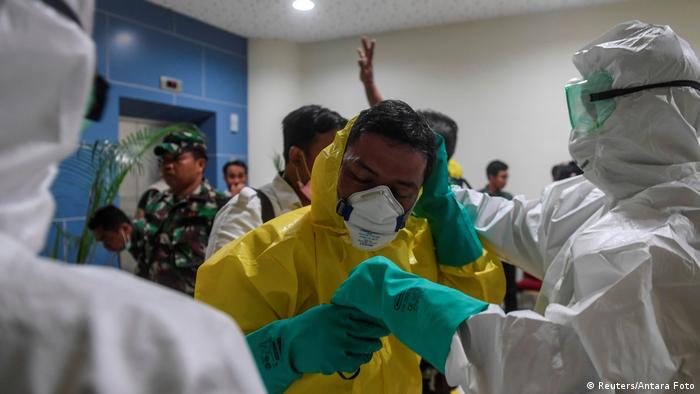 Indonesien | Medizinische Angestellte tragen Sicherheitsanzüge vor evakuierung der Crew der Diamond Princess