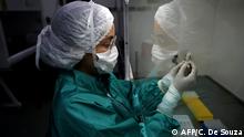An analyst at Fiocruz laboratory, a public health research institute, in Rio de Janeiro holds a sample of mucus to be tested for COVID-19, on March 11, 2020. - The World Health Organisation (WHO) declared the Coronavirus a pandemic with 118,000 cases in about 120 countries, and 4000 deaths. (Photo by CARL DE SOUZA / AFP)