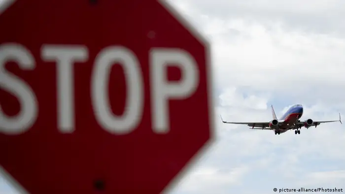 A stop sign and a plane approaching at the Washington National airport. picture-alliance/Photoshot)
