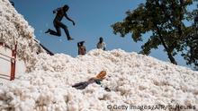 Boys jump from a transport truck onto a heap of cotton in Bakou in the Wewe District, Benin, on January 9, 2018. Cotton is one of the biggest contributors to the national economy of Benin and the country is hoping for a bumper harvest this year. / AFP PHOTO / Stefan HEUNIS (Photo credit should read STEFAN HEUNIS/AFP via Getty Images)