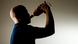 Shadow of a man drinking out of a bottle Shadow of a man drinking out of a bottle
