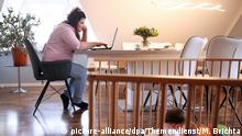 ILLUSTRATION - Eine junge Frau arbeitet am 14.03.2019 in einer Wohnung in Riede an einem Laptop, waehrend ihre Tochter in einem Laufstall sitzt (gestellte Szene). Foto: Mascha Brichta | Verwendung weltweit