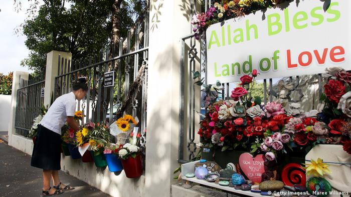A young girl from Marlborough Girls College in Blenheim lays flowers at the entrance of the Masjid An-Nur mosque