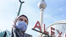 BERLIN, GERMANY - MARCH 16: A young woman wearing a protective face mask against the coronavirus pauses at the request of the photographer while she was walking across Alexanderplatz on March 16, 2020 in Berlin, Germany. Everyday life in Germany has become fundamentally altered as authorities tighten measures to stem the spread of the coronavirus. Public venues such as bars, clubs, museums, cinemas, schools, daycare centers and universities have closed. Many businesses are resorting to home office work for their employees. And travel across the border to most neighbouring countries is severely restricted. (Photo by Sean Gallup/Getty Images)