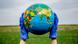 Земной шар держат в защитных перчатках Земной шар держат в защитных перчатках