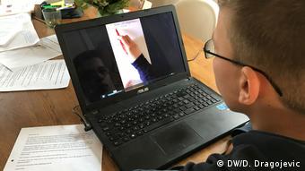 Школьник смотрит обучаеющее видео на экране ноутбука