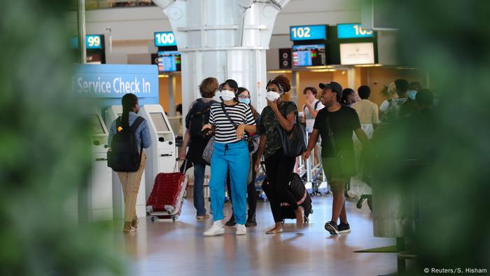 Passersby with protective masks walk through Cape Town International Airport