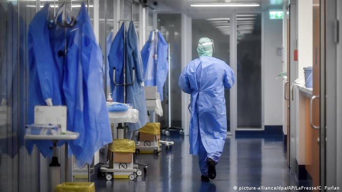 A member of medical staff walks through the intensve care unit of a hospital in Brescia, Italy