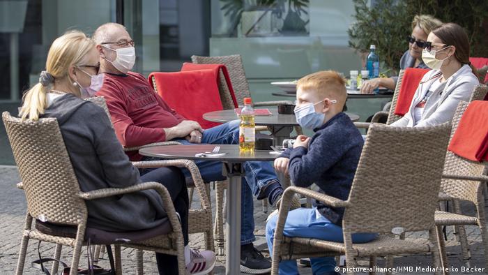 Вюрцбург, Германия: хора с маски седят навън