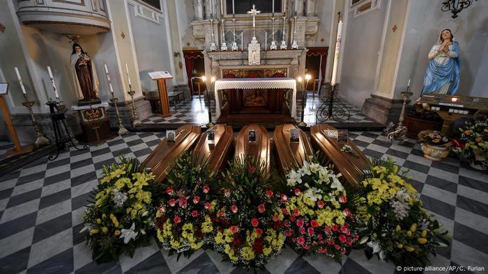 Blumengeschmückte Särge vor einem Altar
