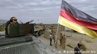 A German soldier in Afghanistan in a vehicle with a German flag