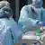 Petugas kesehatan membawa pasien virus corona yang parah ke rumah sakit