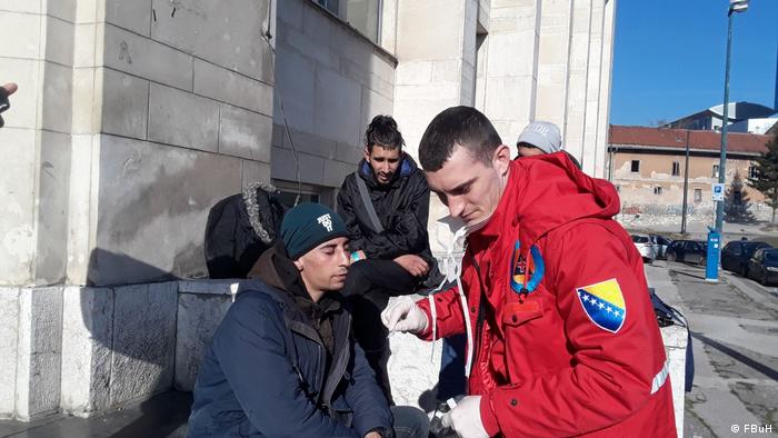 Djelatnik Crvenoga križa BiH razgovara s migrantima