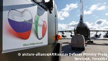 In this Sunday, March 22, 2020, photo supplied by Russian Defense Ministry Press Service, military trucks load onto an Il-76 cargo plane in Chkalovsky military airport outside Moscow, Russia. Nine hulking Il-76 cargo planes are being loaded at the Chkalovsky military airport in Moscow as Russia prepares to send medical personnel and supplies to Italy to help the country's efforts against the coronavirus. The mission include eight mobile medical teams along with medical equipment and aerosol disinfection trucks is to begin Sunday, one day after Russian President Vladimir Putin offered the aid in a telephone conversation with Italian Prime Minister Giuseppe Conte, whose country has confirmed more than 53,000 coronavirus cases and over 4,800 deaths. (Alexei Yereshko, Russian Defense Ministry Press Service via AP)