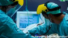 TOPSHOT - Medical workers wearing protective gears work on March 25, 2020, at the level intensive care unit for patients contaminated with coronavirus COVID-19 at Erasme Hospital in Brussels, during a national lockdown in Belgium to curb the spread of COVID-19 (novel coronavirus). (Photo by Kenzo TRIBOUILLARD / AFP) (Photo by KENZO TRIBOUILLARD/AFP via Getty Images)