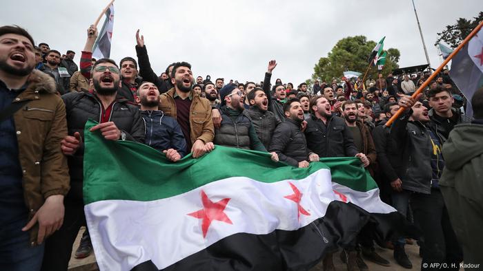 سوريون يحملون علم المعارضة السورية