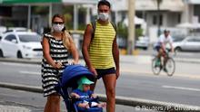 FILE PHOTO: A couple wearing protective face masks walk with their child along the Copacabana beach following the closure of the beaches amid the coronavirus disease (COVID-19) outbreak, in Rio de Janeiro, Brazil March 22, 2020. REUTERS/Pilar Olivares/File Photo