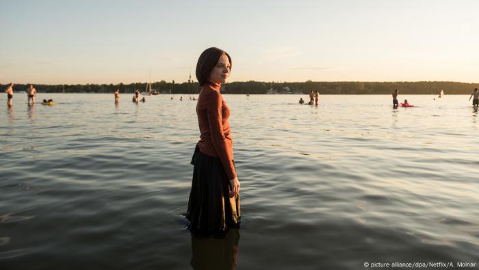A scene showing the protagonist Esty standing knee-deep in water. A scene showing the protagonist Esty standing knee-deep in water.