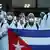 A group of Cuban doctors holding up a flag of their country