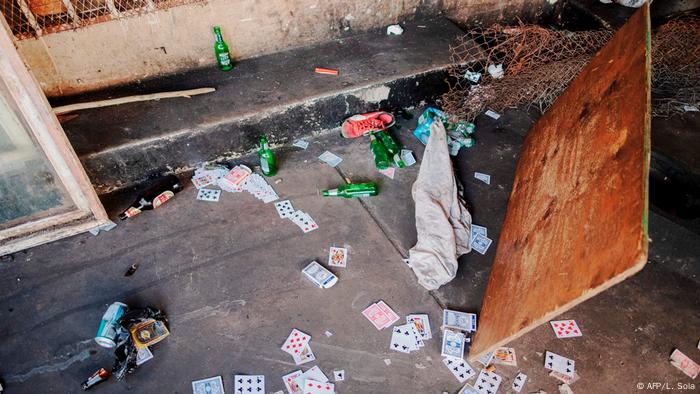 Beer bottles and playing cards scattered on the ground (AFP / L. Sola)