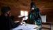 An election official wearning gloves hands out ballot papers in Bamako, Mali An election official wearning gloves hands out ballot papers in Bamako, Mali