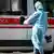 Врач в защитной одежде и медицинский микроавтобус в Киеве
