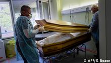 TOPSHOT - Employees of the Lantz funeral company, wearing face masks as protective measures, close the coffin of a victim of the COVID-19 at an hospital in Mulhouse, eastern France, on April 5, 2020 during a strict lockdown in France to stop the spread of COVID-19 (novel coronavirus). (Photo by SEBASTIEN BOZON / AFP)