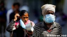People wearing protective masks queue for food inside a sports complex turned into a shelter, during a 21-day nationwide lockdown to slow the spread of the coronavirus disease (COVID-19), in New Delhi, India, April 4, 2020. REUTERS/Adnan Abidi
