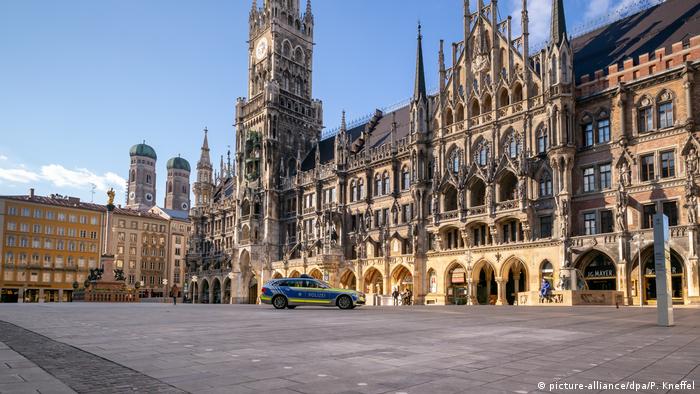 A police car drives over the almost empty Marienplatz square in Munic - Lonely Places (picture-alliance/dpa/P. Kneffel)