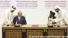 FILE - In this Feb. 29, 2020 file photo, U.S. peace envoy Zalmay Khalilzad, left, and Mullah Abdul Ghani Baradar, the Taliban group's top political leader sign a peace agreement between Taliban and U.S. officials in Doha, Qatar. The Taliban in a statement Sunday, April 5, 2020, said that a peace deal they signed with the United States is near breaking point accusing Washington of violations that included drone attacks on civilians, while chastising the Afghan government for dithering on the release of 5,000 Taliban prisoners, promised in the agreement. (AP Photo/Hussein Sayed, File) |