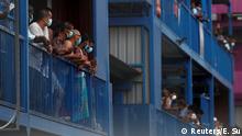 Workers from Bangladesh, India and China look out of their balconies during food distribution at Punggol S-11 workers' dormitory, which was gazetted to be an isolation facility after it became a cluster of coronavirus disease (COVID-19) cases, in Singapore April 6, 2020. REUTERS/Edgar Su TPX IMAGES OF THE DAY