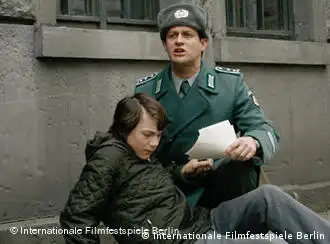 Volkspolizist hält Jungen im Arm - Szene aus Boxhagener Platz (Pandora Film)
