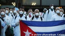 22.03.2020, Italien, Busto Arsizio: Kubanische Ärzte und Fachleute aus dem medizinischen Bereich lassen sich mit einem kubanischen Landesflaggen bei der Ankunft am Flughafen Malpensa fotografieren. Foto: Antonio Calanni/AP/dpa +++ dpa-Bildfunk +++ |