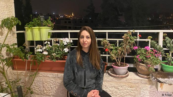 Loreen Msallam sits on a balcony at night in Bethlehem
