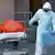 عمال الصحة بإحدى مستشفيات نيويورك ينقلون جثتين لشخصين توفيا بفيروس كورونا