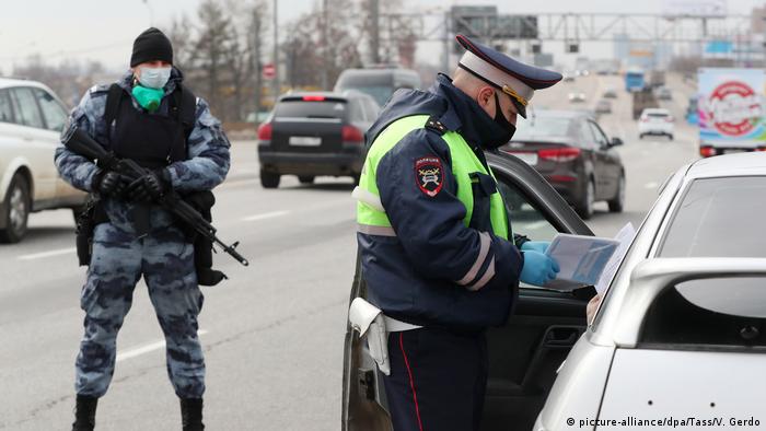 Сотрудник полиции проверяет пропуск для въезда в Москву у водителя на Дмитровском шоссе.