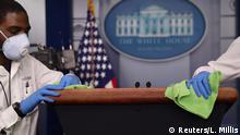 Workers clean the podium before the daily coronavirus disease (COVID-19) outbreak task force briefing in the briefing room at the White House in Washington, U.S., April 13, 2020. REUTERS/Leah Millis