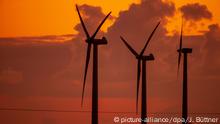 14.04.2020, Mecklenburg-Vorpommern, Brüsewitz: Windräder drehen sich vor dem von der aufgehenden Sonne orangerot gefärbten Morgenhimmel. In Norddeutschland beginnt der Tag mit Temperaturen unter null Grad. Foto: Jens Büttner/dpa-Zentralbild/dpa +++ dpa-Bildfunk +++ | Verwendung weltweit