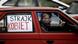 Women drive their car with a "Women's Strike" banner in protest Women drive their car with a "Women's Strike" banner in protest