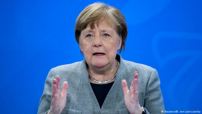 Angela Merkel gestures in a press conference on the coronavirus