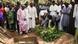 Mourners in Ghana stand around an open grave Mourners in Ghana stand around an open grave