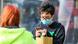 A man wearing a face mask as a preventive measure against the coronavirus views his mobile phone in central London A man wearing a face mask as a preventive measure against the coronavirus views his mobile phone in central London