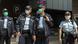 Police officers wearing face masks walk at a down town street in Hong Kong Police officers wearing face masks walk at a down town street in Hong Kong