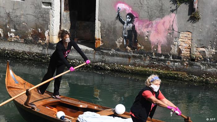 BdTD Venedig Frauen fahren im Boot an Banksy-Kunstwerk vorbei
