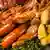 Close-up of a serving of German kale, accompanied with mustard, potatoes and smoked meat, ham and sausages