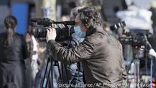 A camerman wearing a mask