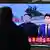 Foto de una persona viendo noticias de Kim Jong Un en la televisión