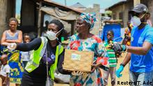 Volunteers gesture as they direct an elderly woman at an ongoing distribution of food parcels, during a lockdown by the authories in efforts to slow the spread of the coronavirus disease (COVID-19), in Lagos, Nigeria April 9, 2020. Picture taken April 9, 2020. REUTERS/Temilade Ade