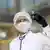 Вирусолог в защитной маске и со шприцом в руке
