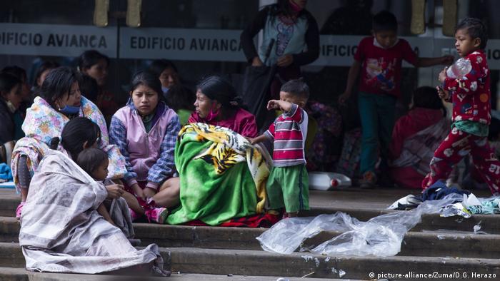 Indígenas sentadas com crianças em escada na Colômbia
